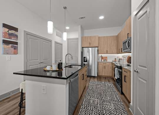A kitchen with a black counter top and wooden cabinets.