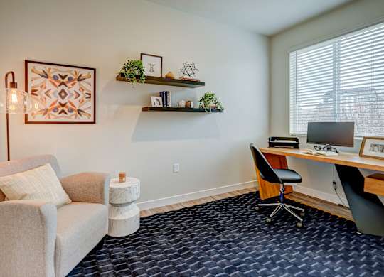 A room with a chair, a desk, and a lamp.