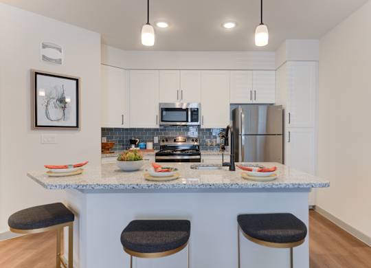 a kitchen with a granite counter top with three stools
