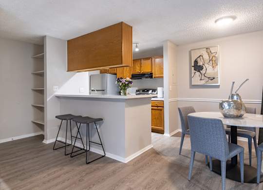 A kitchen with a table and chairs in front of it.