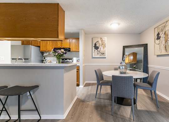 A kitchen with a table and chairs in the foreground.