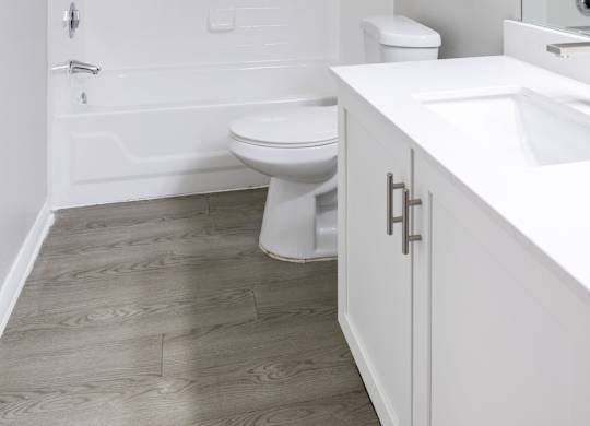 A white bathroom with a toilet, sink, and tub.