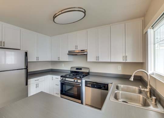 A kitchen with white cabinets and stainless steel appliances.