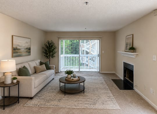 A living room with a couch, coffee table, and fireplace.
