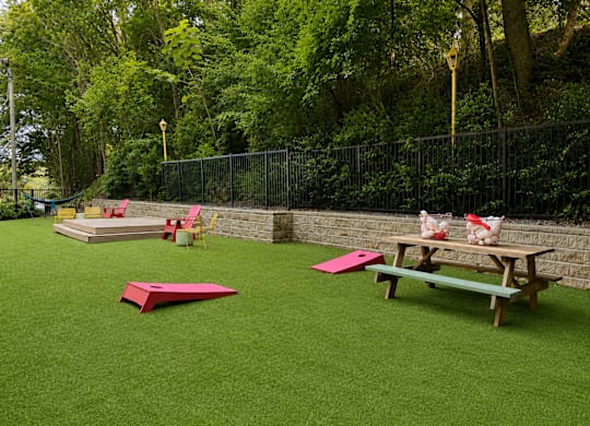 A playground with a green surface and a picnic table.