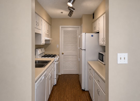 A kitchen with white appliances and cabinets.