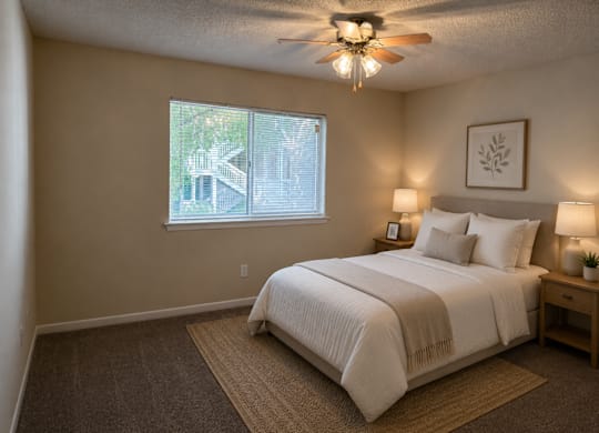 A bedroom with a large bed and a ceiling fan.