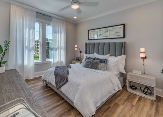 A bedroom with a large bed and a ceiling fan.