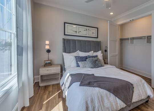 A bedroom with a large bed and a window with curtains.