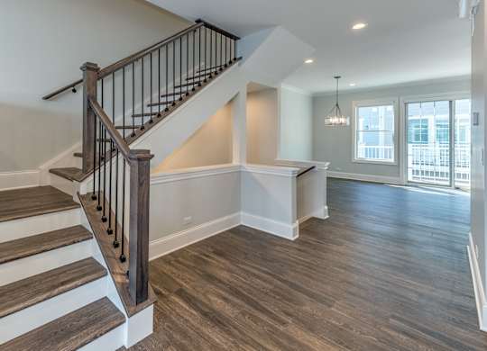 A modern builder grade staircase leading to the second floor with bedrooms and a first floor nook in the living room for a desk.