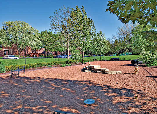 A dog park with a red surface and a blue frisbee.