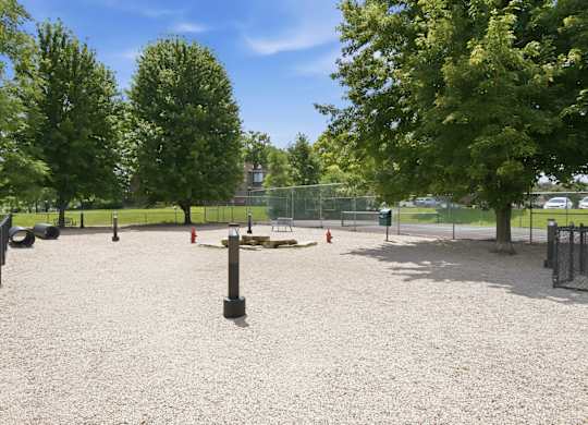 A playground with a sandy area and a fence.