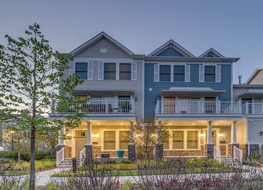A townhome complex at twilight with porch lights on.