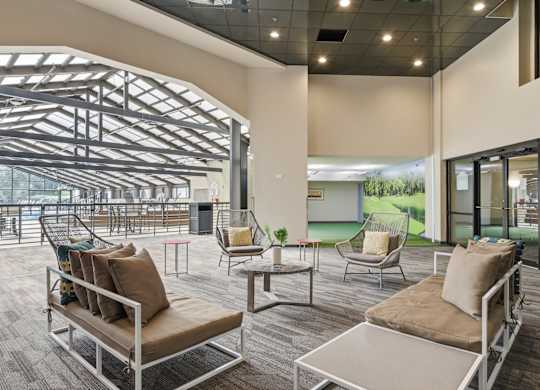 A modern outdoor seating area with a glass wall and a metal roof.