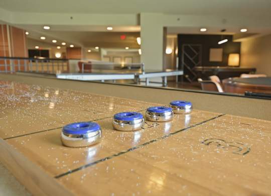 A shiny pool table with blue and silver coins on it.