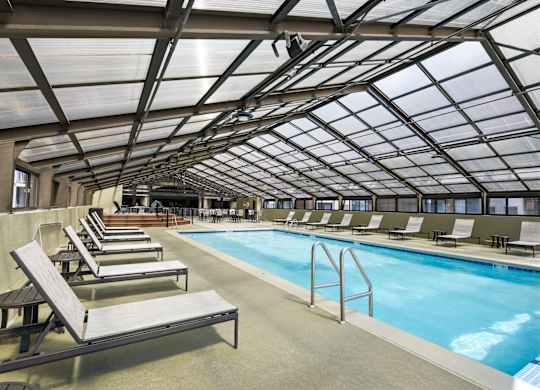 A large indoor swimming pool with sun loungers.