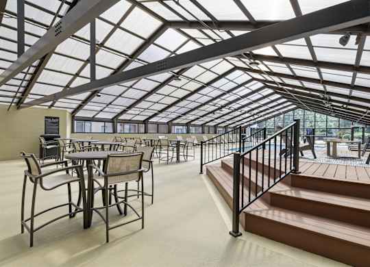 A glass-roofed patio with tables and chairs.