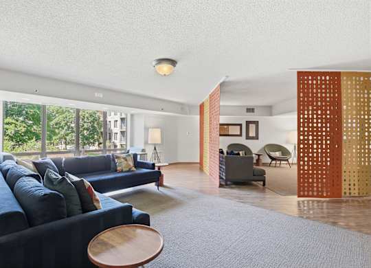A living room with a blue couch and a wooden table.