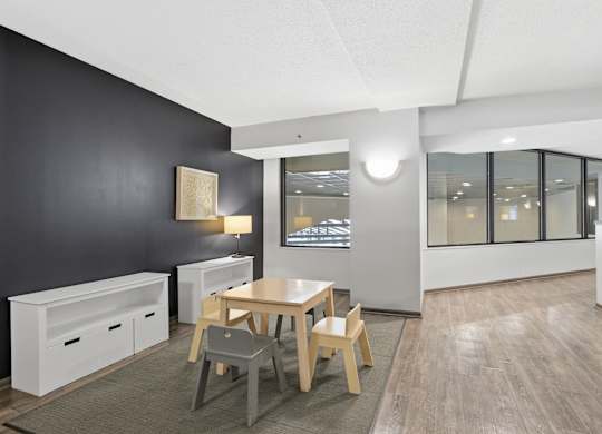A modern dining room with a wooden table and chairs.