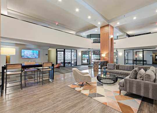 A modern living room with a grey sofa and a wooden floor.