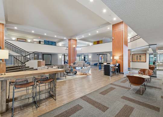 A spacious lobby with a staircase and a bar area.