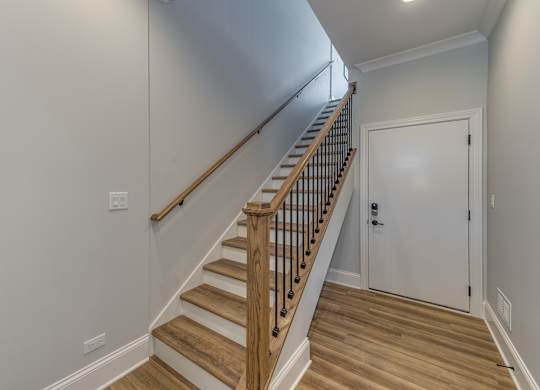 A modern builder grade staircase leading to the second floor with the bedrooms.