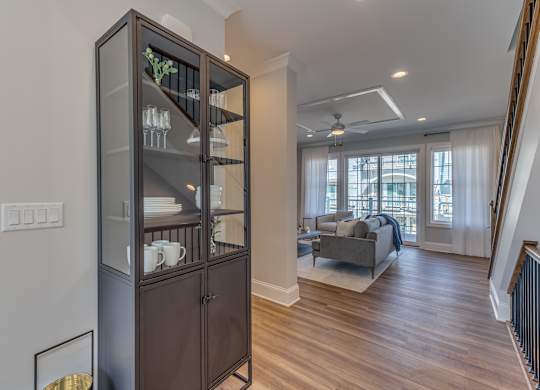 The area between the kitchen/dining room area and the living room area with a blue cabinet housing extra storage and decor.