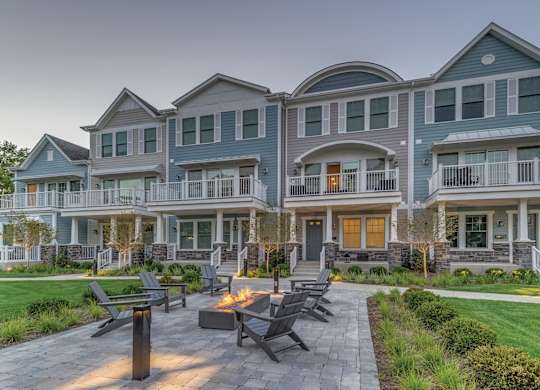 A townhome complex patio with fire pit and chairs on a brick walkway.