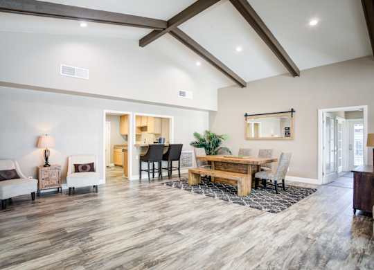 A spacious living room with a wooden floor and a high ceiling.