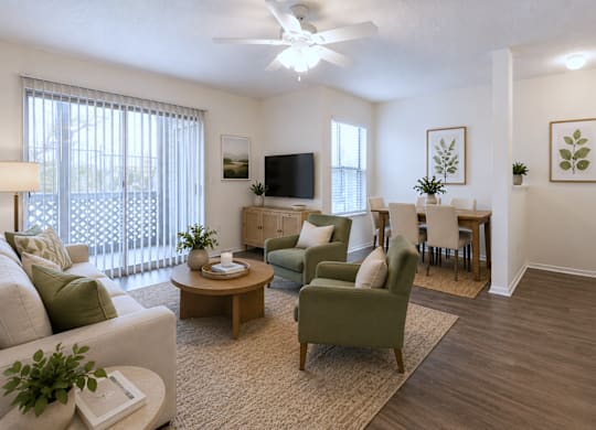 A living room with a white ceiling fan and a flat screen TV mounted on the wall.