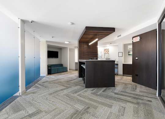 Main room of the business center with a community work table, conference rooms on the sides, and printer in the background.