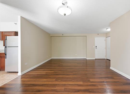 A living room with wooden floors and front hall closet.