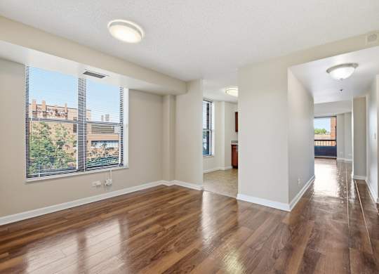 a living room with wooden floors and window.