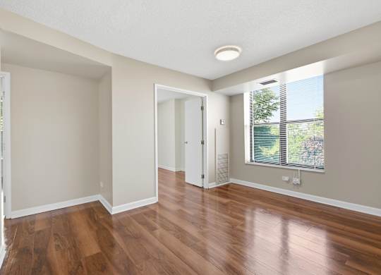 a living room with wooden floors and window.