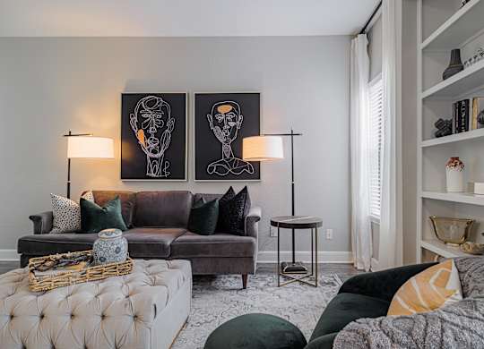 a living room with a couch and a chair and a book shelf