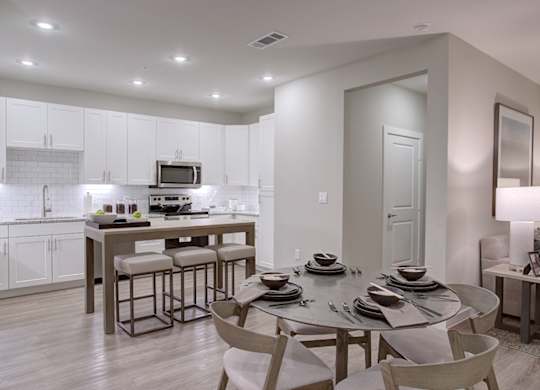 A modern kitchen with a dining table set for four.