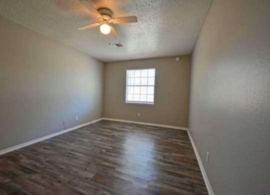 A room with a ceiling fan and a window.