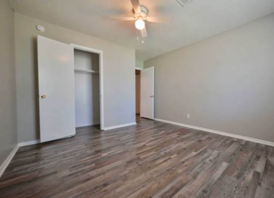 A room with wooden flooring and two doors.