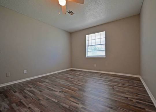 A room with wooden flooring and a window.