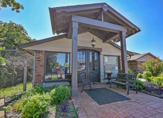 A small house with a porch and a fence.
