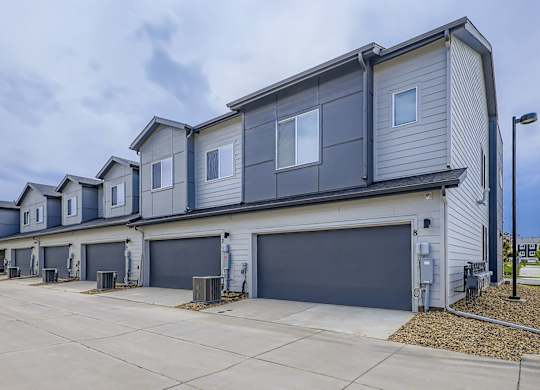 A row of houses with garages in front.