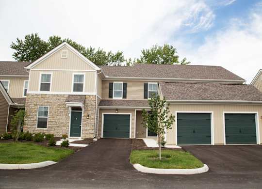 A two-story house with a garage and a driveway.