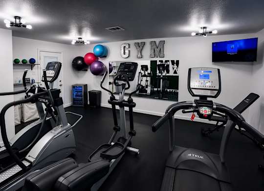 A gym with treadmills and elliptical machines.