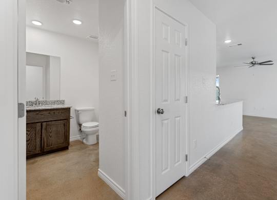 a bathroom with a white door and a toilet and a sink
