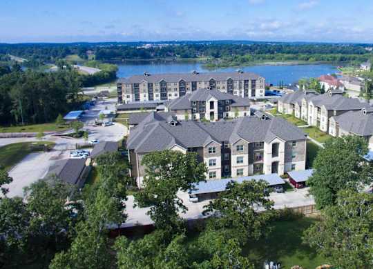 A large building complex with a lake in the background.