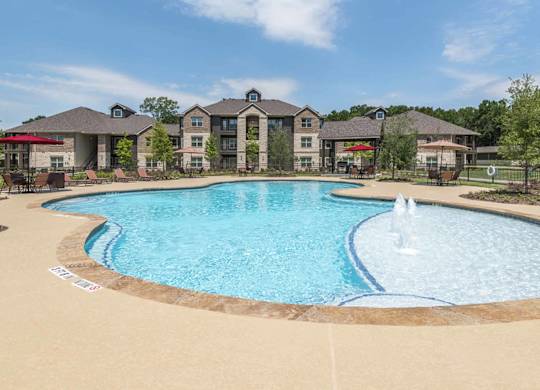A large swimming pool with a fountain in the middle of it.