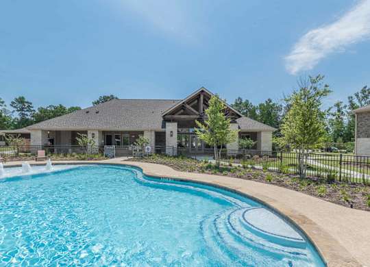 A large swimming pool in front of a house.
