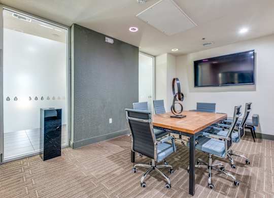 A conference room with a wooden table and chairs.