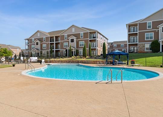 A swimming pool in front of apartment buildings.