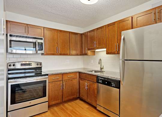 A kitchen with wooden cabinets and stainless steel appliances.